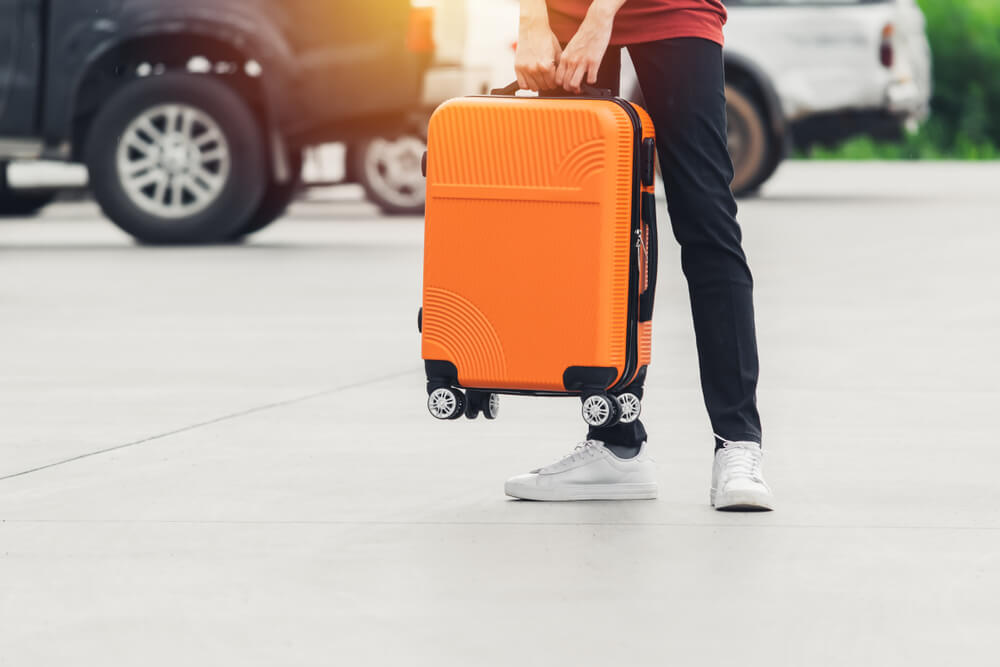 "Person holding a suitcase ready for a trip with triptirupathi.com, providing taxi and driver services in Tirupati"